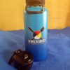 Water Is Life All Day Thermos Blue water bottle with UNCEDED logo and black lid on blue surface.