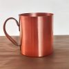 Solid Copper Mug for Hot Beverages Copper mug with handle on wooden surface, ideal for hot drinks.