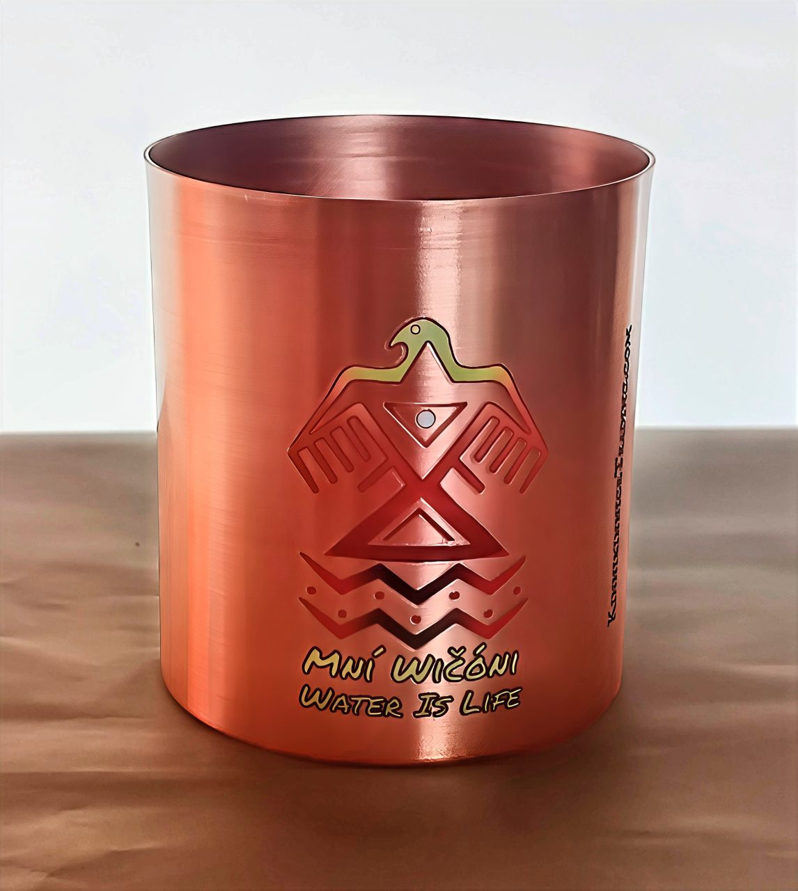 Copper mug with Indigenous-inspired design and 'Water is Life' inscription.