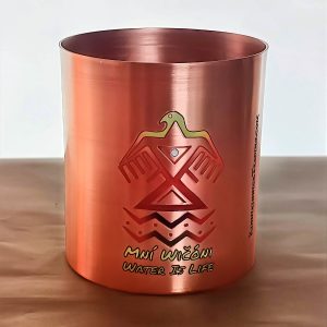 Copper mug with Indigenous-inspired design and 'Water is Life' inscription.